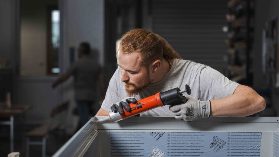 Sealing the façade element with silicone during production.