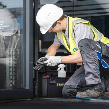 GIG technician performing door maintenance according to ÖNORM B 5305 and AMFT guidelines, extending the service life.