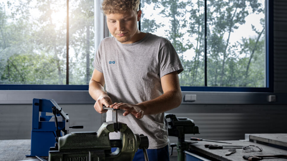 A metal technology apprentice filing as part of the apprenticeship training.