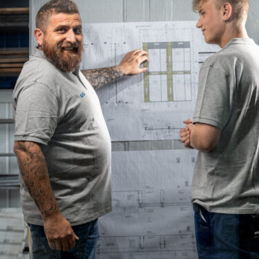 Construction plan discussion between the trainer and the metal technology apprentice.