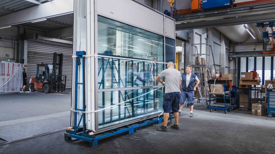 Façade elements are secured and packaged on reusable racks for international shipping.