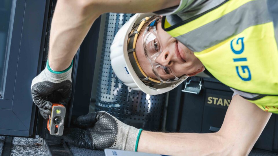 Technician measuring a façade for a renovation using a handheld laser.