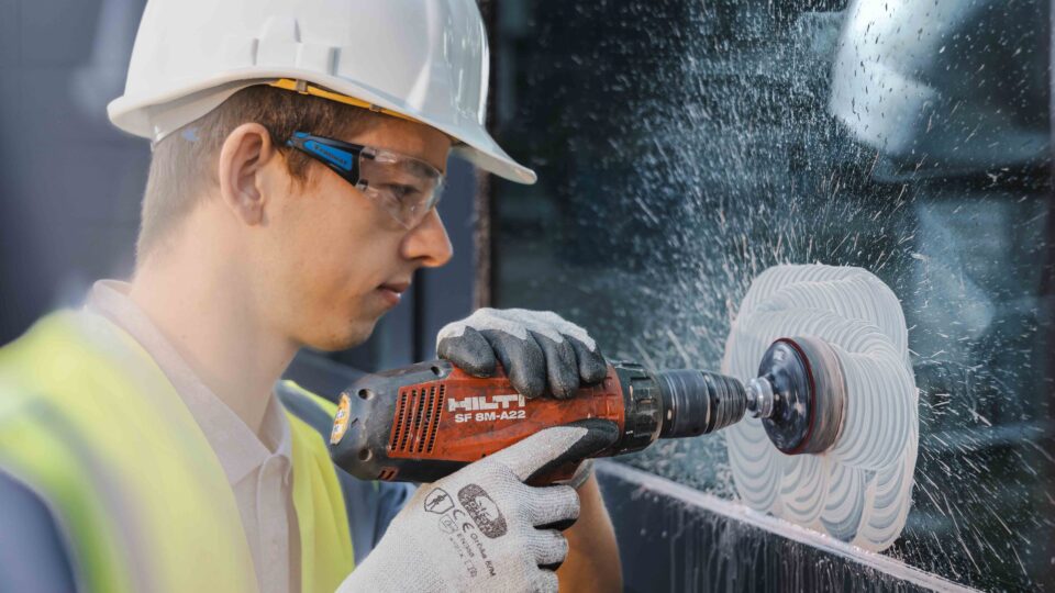 Technician polishes scratches out of glass panes.