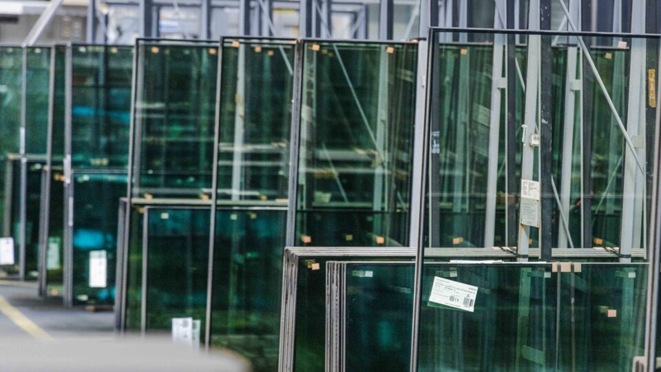 Glass panes on reusable racks for the production of structural glazing façade elements.