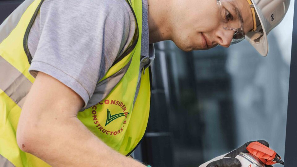 Technician performing window service according to ÖNORM B5305; lubricating the window fittings.